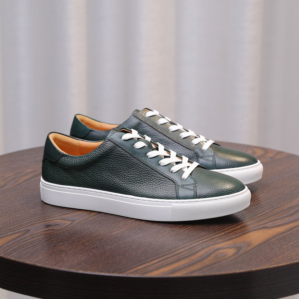 Green leather low-top sneakers with white laces and white rubber sole