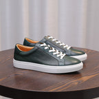 Green leather low-top sneakers with white laces and white rubber sole