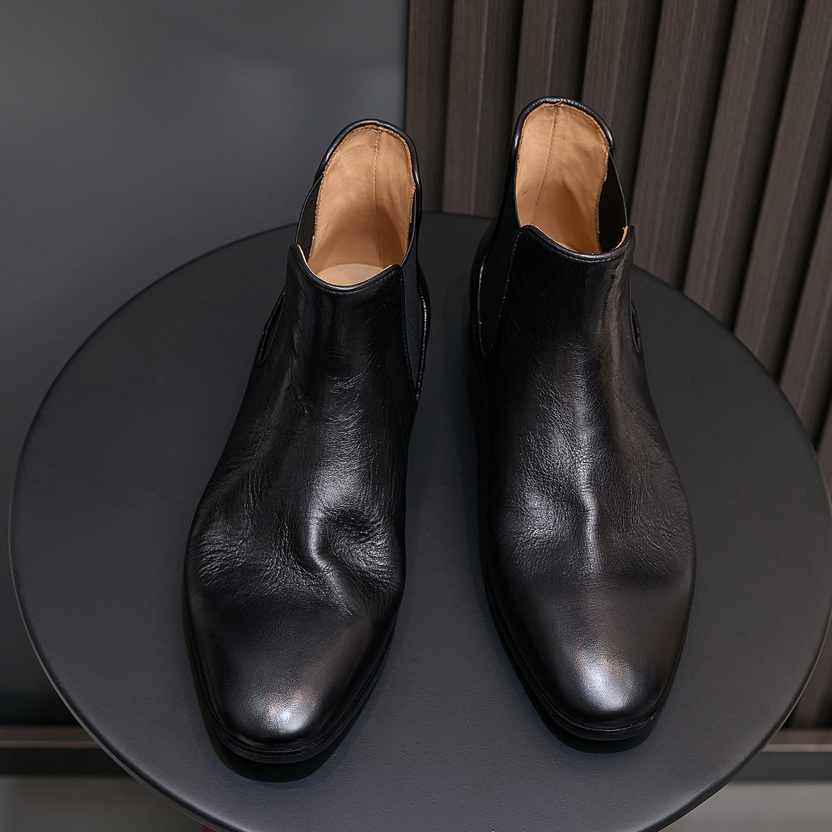 Pointed-toe suede Chelsea dress boots in black with tan interior lining