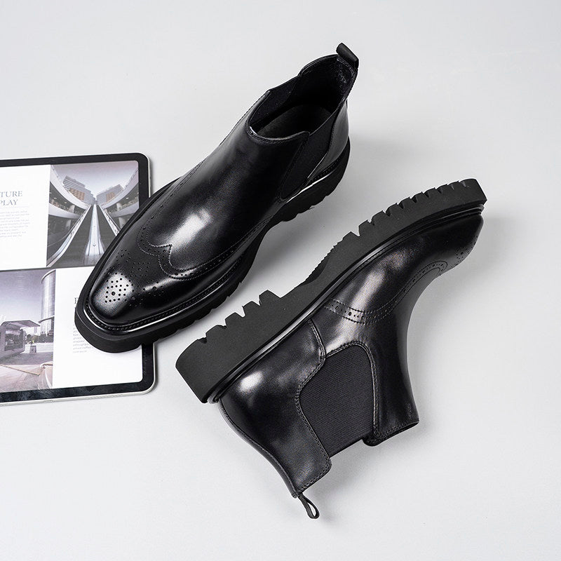 Black leather Chelsea dress boots with elastic gore, perforated toe, chunky tread sole