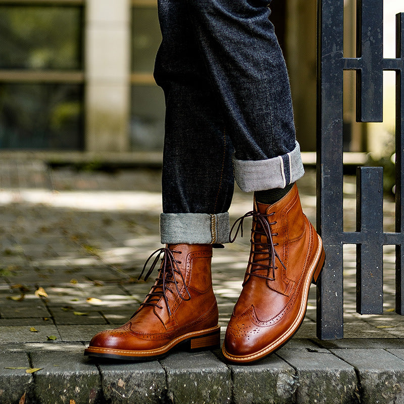 Men's brown leather chukka boots with lace-up front, worn with jeans cuffs