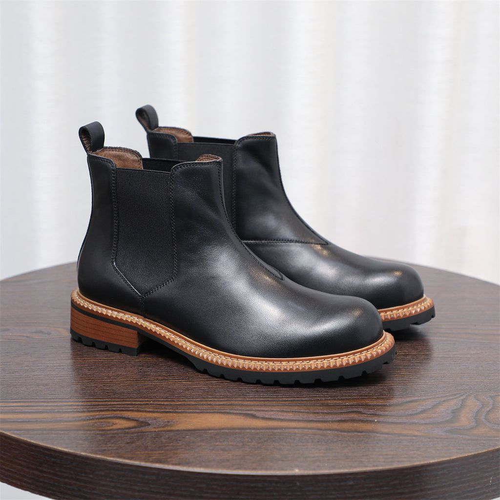 Black pointed-toe Chelsea boots with elastic side panels and lug sole, low stacked heel