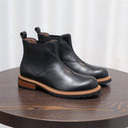Black pointed-toe Chelsea boots with elastic side panels and lug sole, low stacked heel