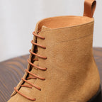 Tan suede lace-up chukka boot with padded collar and extended lace eyelets