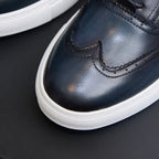 Close-up of dark blue leather sneaker toe with lace-up and white sole