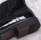 Men's black formal dress boots close-up: thick block heel with glossy toe