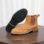 Brown suede pointed-toe Chelsea boot with visible outsole tread and elastic side panel