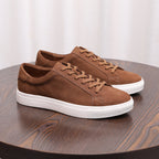 Tan brown suede leather sneakers with lace-up front and white rubber sole.