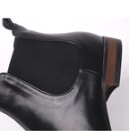 Close-up of black Chelsea boot upper with elastic gore panel and stitching.