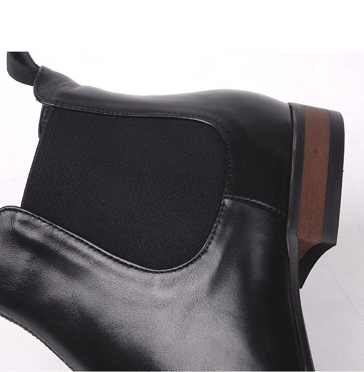 Close-up of black Chelsea boot upper with elastic gore panel and stitching.