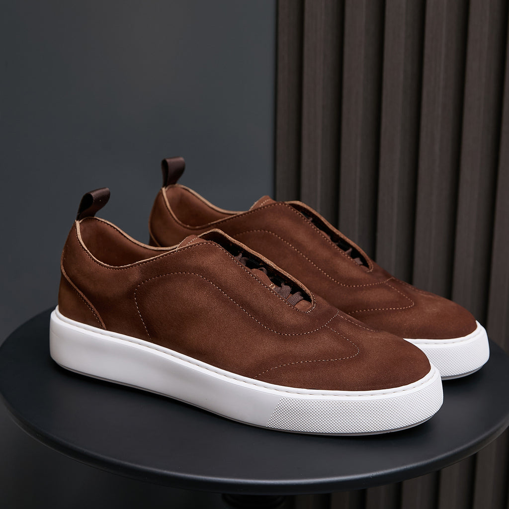Brown leather sneakers with lace-up front and white rubber sole on display