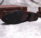 Black boot outsole view with tread pattern and small embossed logos on heel