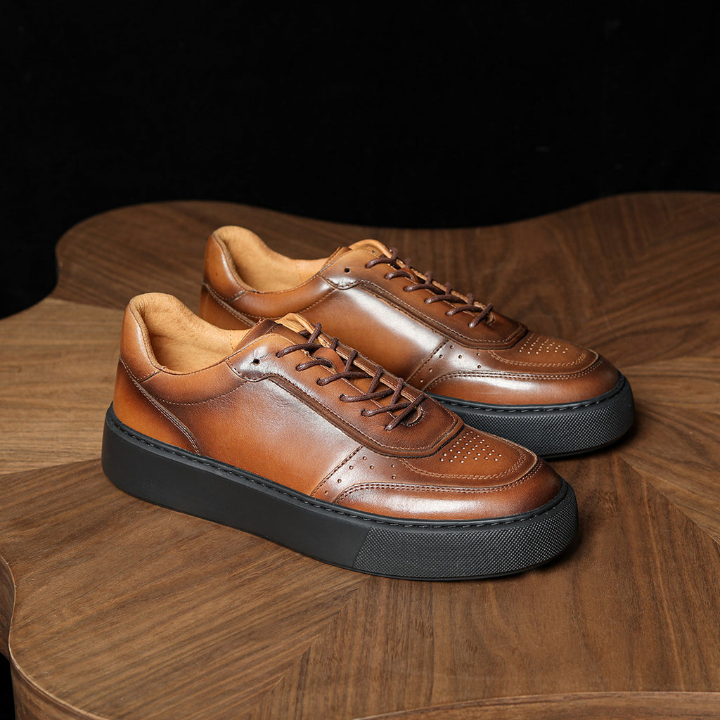 Brown leather lace-up sneakers with glossy panels and thick black platform sole.