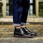 Men's black leather lace-up chukka boots, side view, plain toe and rugged sole