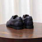 Men's dark gray leather sneakers, rear view with cushioned heel and rubber sole