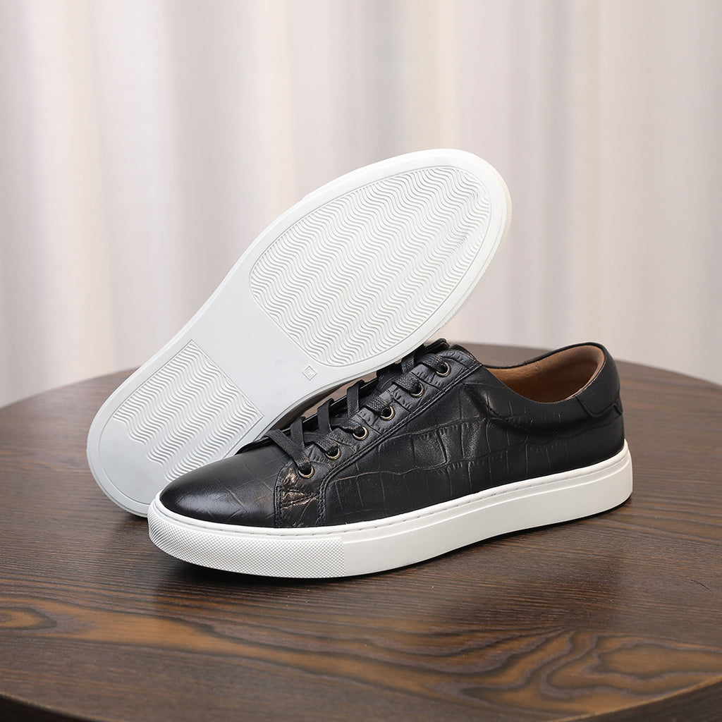 Black leather sneakers with visible sole tread and lace-up upper