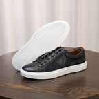 Black leather sneakers with visible sole tread and lace-up upper