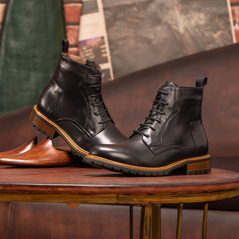 Pair of black pointed-toe leather ankle boots with lace-up and side-zip, on wooden stand.