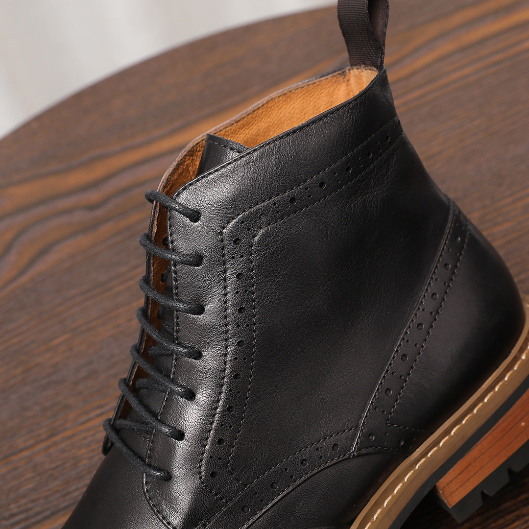 Black leather lace-up chukka boot close-up with perforations and tan outsole trim