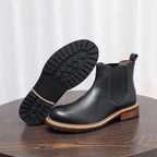 Black Chelsea boot with outsole tread visible and pointed toe, elastic gore side panel