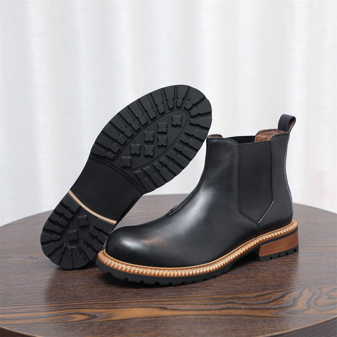 Black Chelsea boot with outsole tread visible and pointed toe, elastic gore side panel