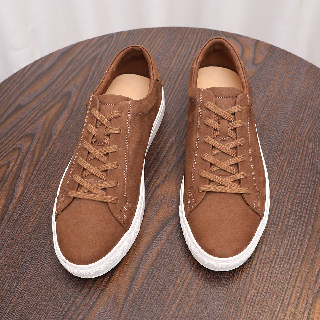 Brown suede leather sneakers with lace-up front and white rubber sole.