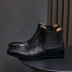 Black pointed-toe Chelsea dress boots with elastic side panels and low-profile sole