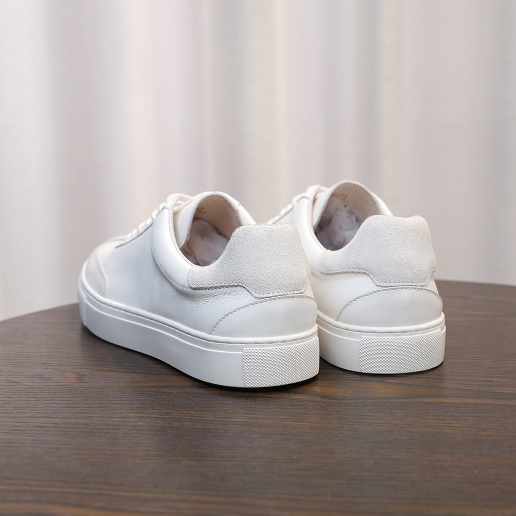 Men's white leather sneakers, rear view with lace-up closure and cushioned heel