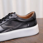Men's leather sneakers, black, close-up of smooth leather vamp and lace-up.