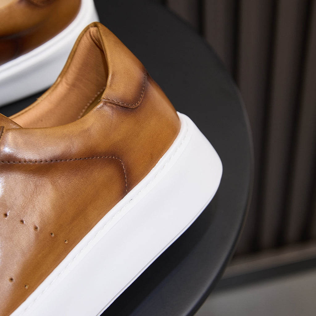 Men's brown leather sneaker collar and white midsole edge close-up
