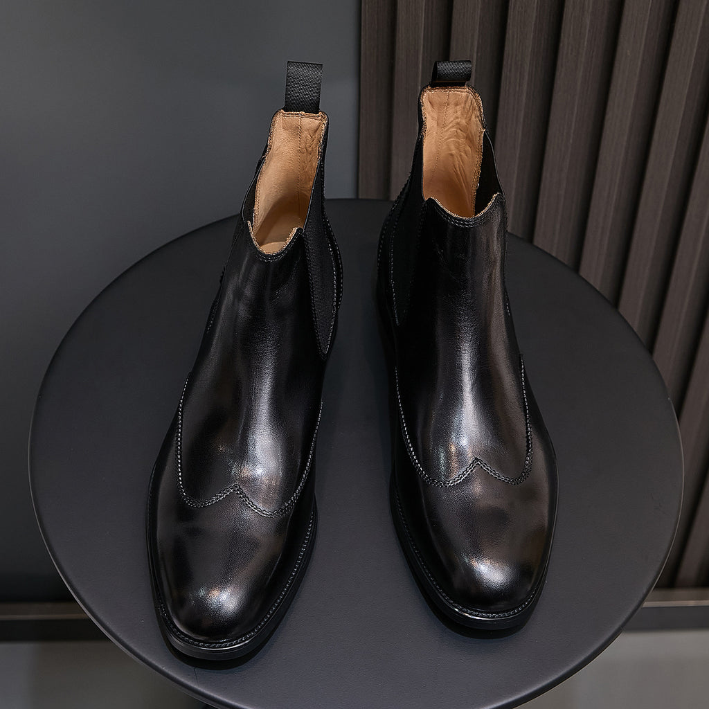Pair of men's pointed-toe black chelsea boots with elastic sides and pull tabs