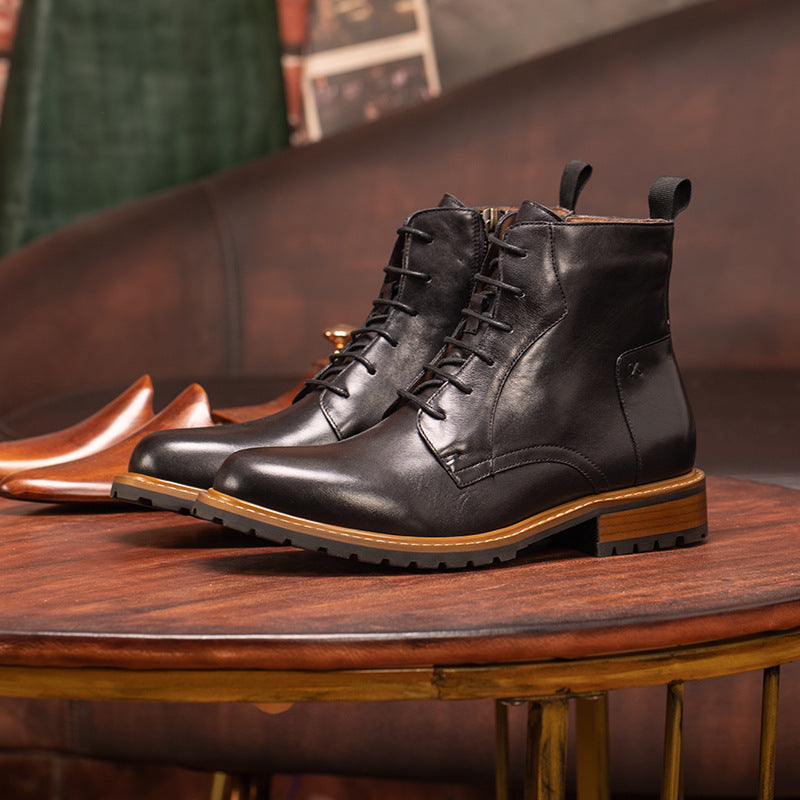 Black pointed-toe leather ankle dress boots with lace-up and side-zip, resting on bench.