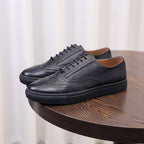 Men's black leather low-top sneakers with lace-up front and dark rubber sole