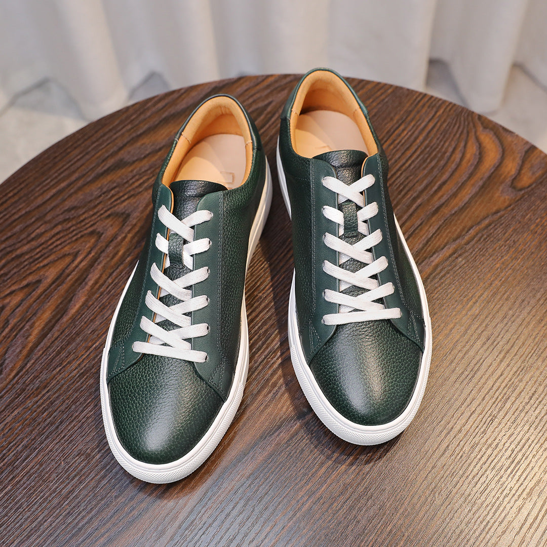 Pair of green leather lace-up sneakers with white laces and white rubber soles