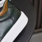 Close-up of men's dark green leather sneaker side and white platform sole