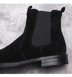 Black suede Chelsea boot close-up, elastic side panel and rounded toe