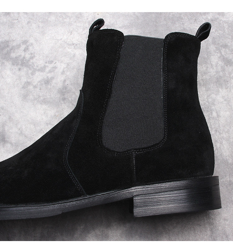Black suede Chelsea boot close-up, elastic side panel and rounded toe