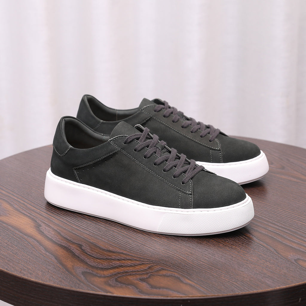 Dark gray leather low-top sneakers with lace-up front and white rubber sole