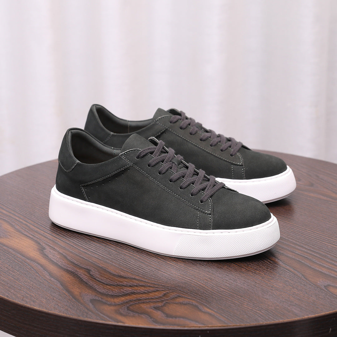 Dark gray leather low-top sneakers with lace-up front and white rubber sole