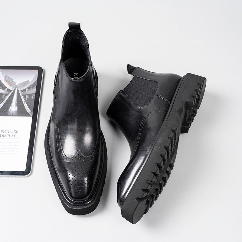 Black leather Chelsea dress boots showing treaded sole and elastic side gore panels