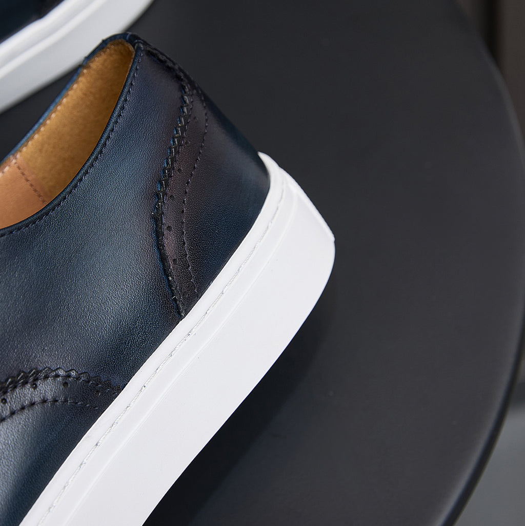 Close-up of dark blue leather sneaker side panel with white rubber sole