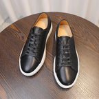 Men's leather sneakers, black leather lace-up pair with white rubber soles.