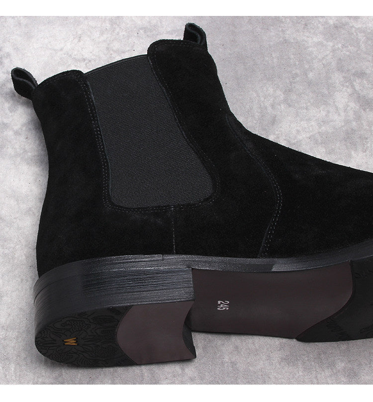 Black suede Chelsea boots close-up, elastic gore and textured midsole detail