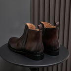 Men's pointed-toe leather dress boots with side zip, dark brown leather and black sole.