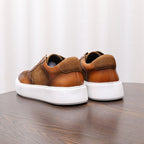 Brown leather sneakers from back view with white heel sole and lace-up openings