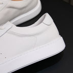 White genuine leather sneaker side view, smooth collar with lace-up panel
