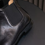 Black pointed-toe Chelsea dress boot with elastic gore and stitched seam detail