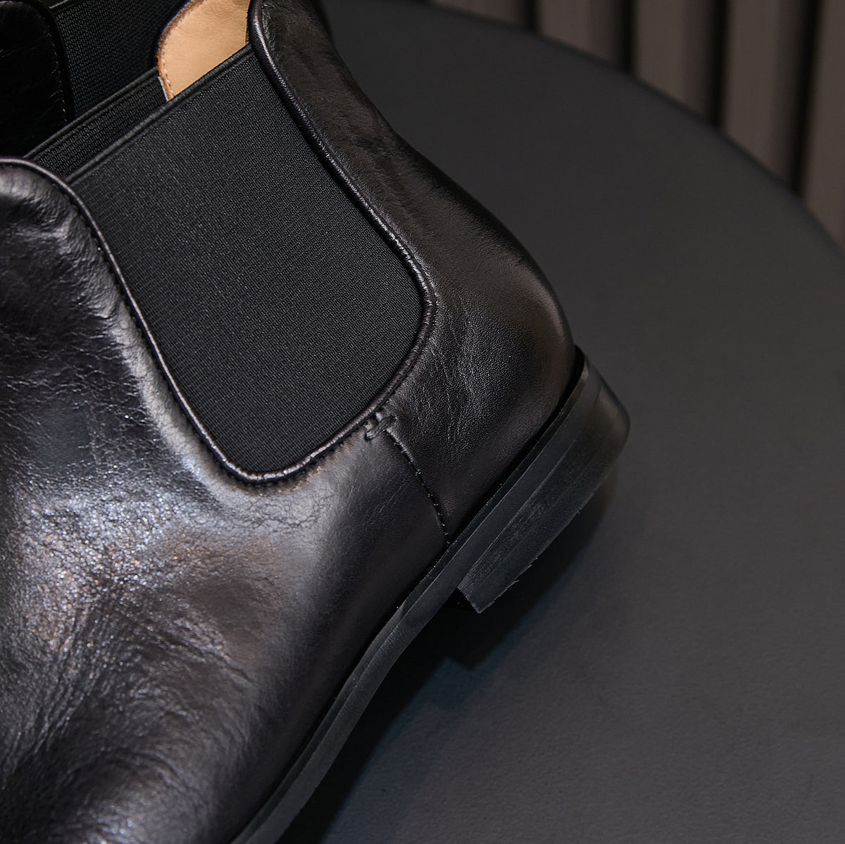 Black pointed-toe Chelsea dress boot with elastic gore and stitched seam detail