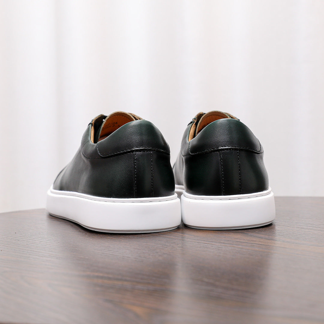 Back view of men's dark leather sneakers with white rubber sole and heel panel stitching