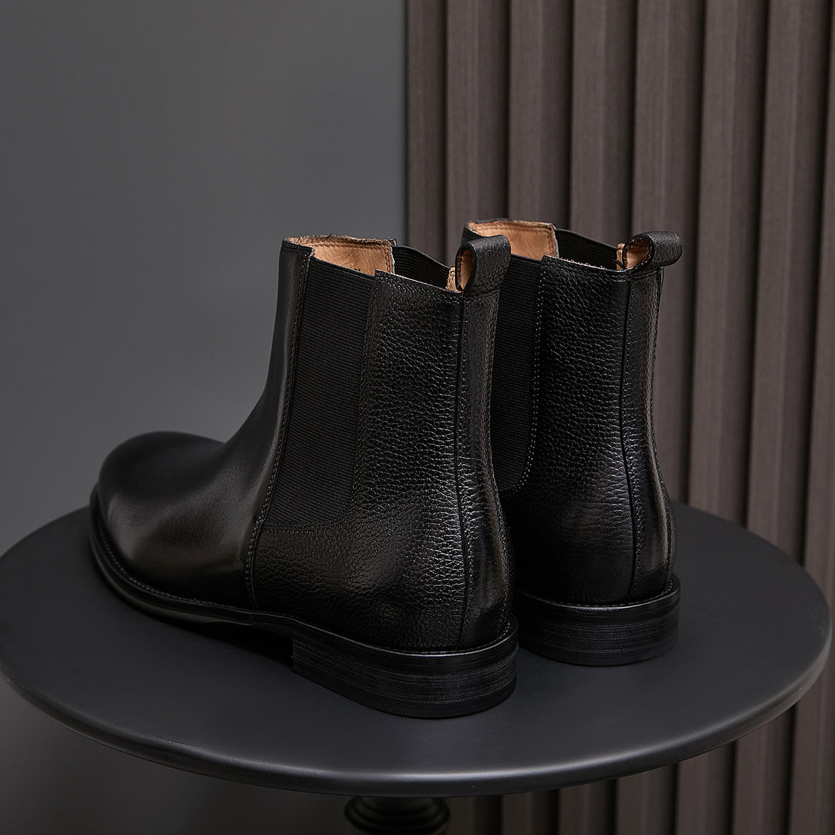 Pair of black chelsea dress boots with elastic side panels and low stacked heel